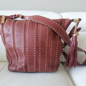 Michael Kors lether Brooklyn grommets a bag with a sholder strap. Brick color.